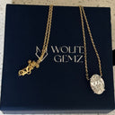 Gold necklace with a pendant on a Wolfe Gemz branded box