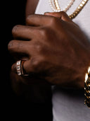 Hand showcasing custom diamond ring with layered gold chains, handcrafted NYC jewelry